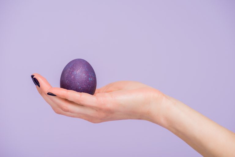 Hand holding a purple egg